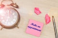 Make an Appointment on pink sticky note on office table with alarm clock and pen Royalty Free Stock Photo