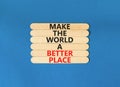 Make a better world symbol. Concept words Make the world a better place on wooden stick. Beautiful blue table blue background.