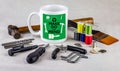 Make do and mend logo on coffee mug surrounded by tools on table cloth, homespun movement for sustainable living and to reduce