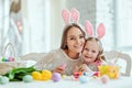 Make Easter preparation fun and sweet.Mom and daughter are preparing for Easter together.On the table is a basket with Easter eggs Royalty Free Stock Photo