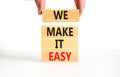 We make it easy symbol. Concept words We make it easy on wooden cubes. Beautiful white table white background. Businessman hand.