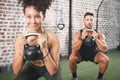 Make every squat count. two sporty young people using kettlebells while working out at the gym. Royalty Free Stock Photo