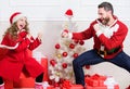 Make it fun. Christmas games. Kid cute girl play with father near christmas tree. Playful daughter and dad celebrate Royalty Free Stock Photo