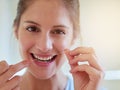 Make it a habit. Portrait of a young woman flossing her teeth in a bathroom. Royalty Free Stock Photo