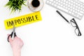 Make the impossible possible. Cutting the part im of written word impossible by sciccors. Office desk. White background Royalty Free Stock Photo