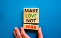 Make love not war symbol. Concept words Make love not war on wooden blocks. Businessman hand. Beautiful blue table blue background Royalty Free Stock Photo