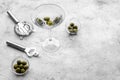 Make martini cocktails. Glass with beverage, olives and utensils on grey stone background top view copyspace Royalty Free Stock Photo