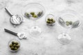 Make martini cocktails. Glass with beverage, olives and utensils on grey stone background top view copyspace Royalty Free Stock Photo
