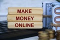 Make money online text on wooden blocks on top of keyboard computer with gold coins and bank notes. Online business Royalty Free Stock Photo