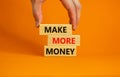 Make more money symbol. Concept words Make more money on blocks on beautiful orange table orange background. Business, make more Royalty Free Stock Photo