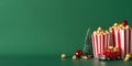 Side view photograph features table with popcorn, festive ornaments, miniature car, fir on green backdrop