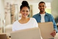 They make moving house look easy. Portrait of a happy young couple carrying cardboard boxes into their new home. Royalty Free Stock Photo