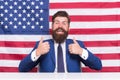 Make our land the absolute best country. Happy hipster give thumbs ups. USA flag background. Bearded man gesturing Royalty Free Stock Photo