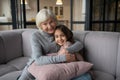 Grandmother and granddaughter hugging and smiling sitting on a sofa. Royalty Free Stock Photo