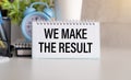 WE MAKE RESULT text on a paper with glasses and keyboard on a white background. Royalty Free Stock Photo