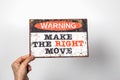 Make The Right Move. Warning sign with text in the hands of a woman