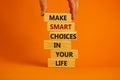 Make smart choice symbol. Concept words `Make smart choice in your life` on wooden blocks on a beautiful orange background.