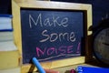 Make some noise! on phrase colorful handwritten on blackboard.