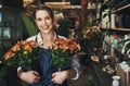 Make someone smile today with these beauties. Portrait of an attractive young florist holding potted flowers inside a