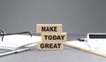 MAKE TODAY GREAT text on wooden block with notebook,chart and calculator, grey background Royalty Free Stock Photo