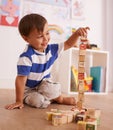 Make the tower bigger. A young boy playing with his building blocks in his room. Royalty Free Stock Photo