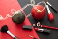 Make-up accessories and xmas decoration against red and black background, copy space Royalty Free Stock Photo