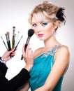 Make-up artist in action on beautiful doll face