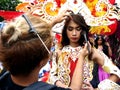 A make up artist applies make up to a parade participant in her colorful costume during the Sumaka Festival in Antipolo City.