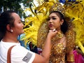 A make up artist applies make up to a parade participant in her colorful costume during the Sumaka Festival in Antipolo City.