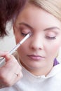 Make-up artist applying with brush color eyeshadow on female eye Royalty Free Stock Photo