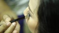 Make-up artist doing eye shadows to a young woman