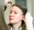 Make-up artist making eyebrow correction.