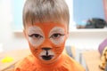 Make up artist making tiger mask for child.Children face painting. Boy painted as tiger or ferocious lion