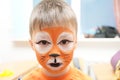 Make up artist making tiger mask for child.Children face painting. Boy painted as tiger or ferocious lion Royalty Free Stock Photo