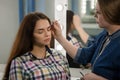 Make-up artist plucks eyebrows to client