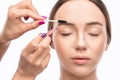 Make-up artist plucks eyebrows with tweezers to a woman before staining with henna.Makeup concept, eyebrow shape modeling and Royalty Free Stock Photo