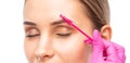 Make-up artist plucks eyebrows with tweezers to a woman before staining with henna.Makeup concept, eyebrow shape modeling and Royalty Free Stock Photo