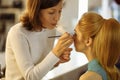 Make-up artist preparing model in a dressing room before photosession Royalty Free Stock Photo