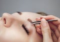 The make-up artist pulls out a pair of tweezers to a beautiful young girl in a beauty salon Royalty Free Stock Photo