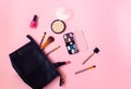 Make-up bag with cosmetic beauty products and make-up brushes on pink background Royalty Free Stock Photo