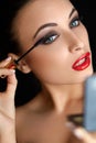 Make-up. Beautiful Woman Doing Makeup. Mascara Brush. Red Lips Royalty Free Stock Photo