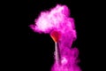 Make-up and beauty concept. Brush with pink powder explosion on black background Royalty Free Stock Photo