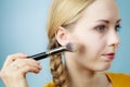 Makeup artist applying with brush rouge on female check Royalty Free Stock Photo