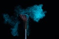 Make-up brush with blue powder explosion isolated on a black background Royalty Free Stock Photo