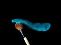 Make-up brush with blue powder explosion isolated on black background Royalty Free Stock Photo