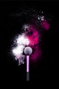 Make-up brush with colorful powder on black background. Explosion stars dust with bright colors. White and pink powder red Royalty Free Stock Photo