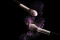 Make up brush and powder explosion purple color isolated on black background