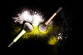 Make-up brush with white powder spilled glitter dust on black background. Makeup brush on new year`s Party with bright colors. Royalty Free Stock Photo