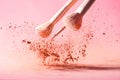 Make up brushes with powder splashes isolated on pink background Royalty Free Stock Photo