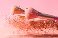 Make up brushes with powder splashes isolated on pink background Royalty Free Stock Photo